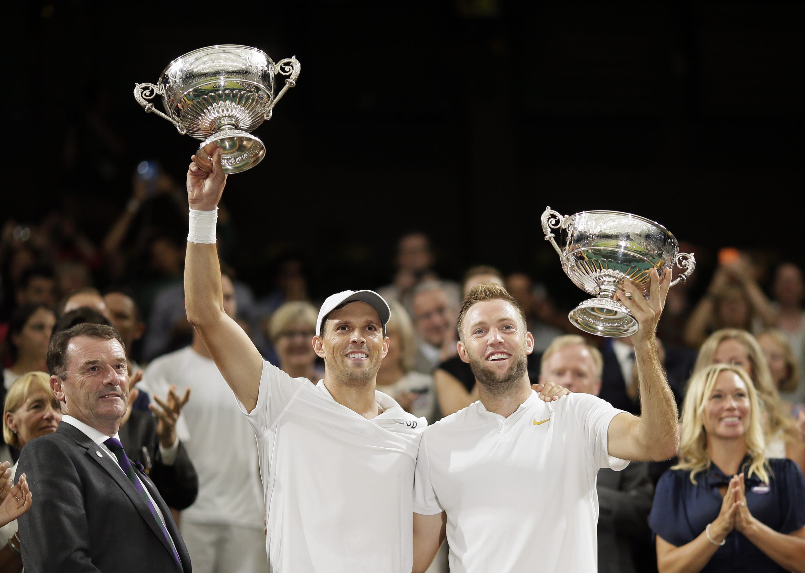 Mike Bryan, left, and Jack Sock of the US hold up their trophies after defeating South Africa's Raven Klaasen and New Zealand's Michael Venus in the men's doubles final match at the Wimbledon Tennis Championships, in London